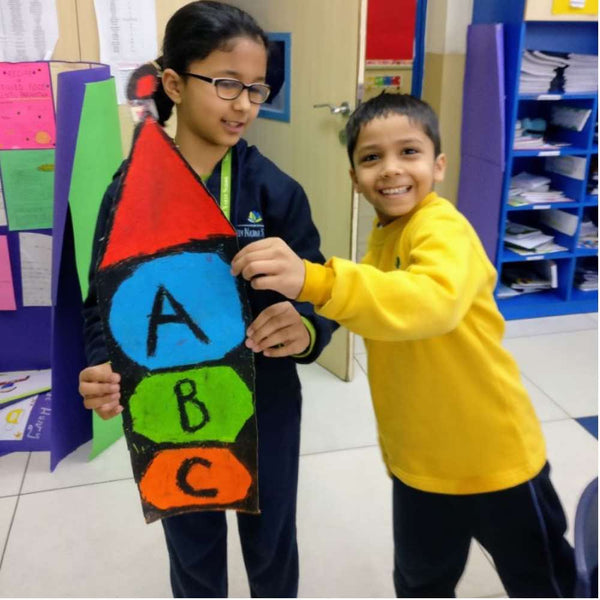 children hold a paper model of Daily Dump khamba composter