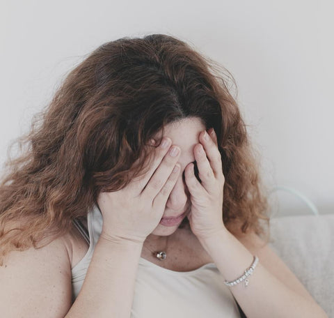femme inquiète tenant son visage pleurant pms périodes douloureuses stressées