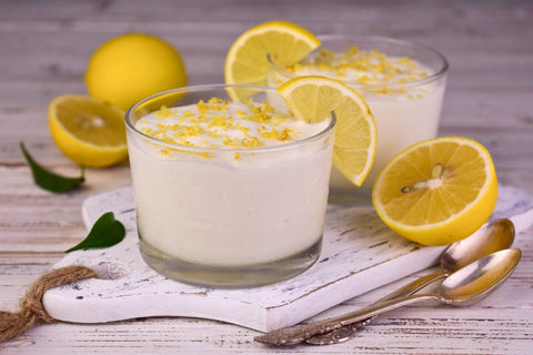 Mousse au limoncello et chocolat blanc dans un petit verre avec du zeste de citron.