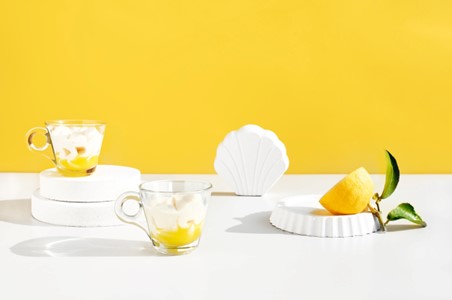 Un dessert au citron sur une table blanche avec un mur jaune en arrière-plan
