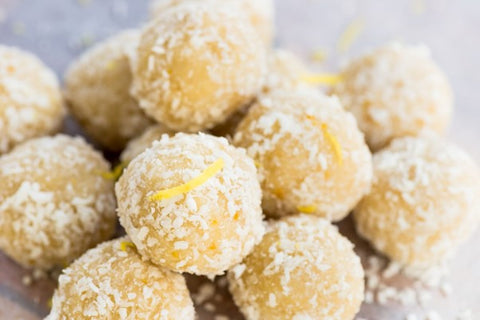 Un tas de truffes au limoncello recouvertes de noix de coco desséchée et de zeste de citron.