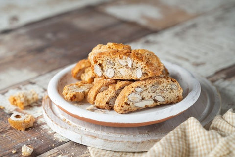 Une assiette de biscottis au limoncello posée sur une planche à découper blanche.