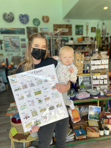 Amandalee holding Central Coast Alphabet Poster in Smoobage, located in Morro Bay, CA