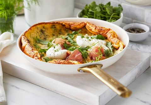 Parmesan Herb Dutch Baby in a GreenPan 10" frypan on a marble countertop.