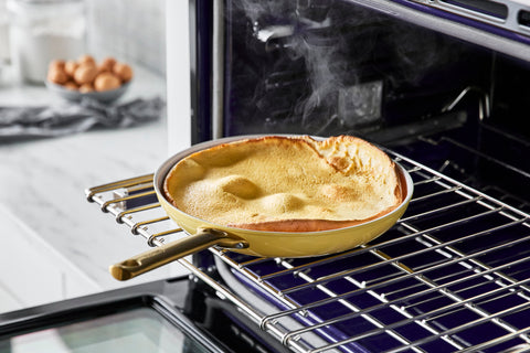 A Dutch Baby made in a GreenPan Reserve Sunrise 10" Frypan and sitting in an oven.