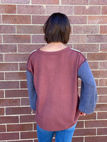 girl wearing color block henley style top - back view