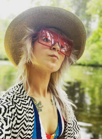 woman with sunglasses and hat posing for a selfie 