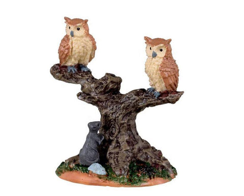 Beautifully crafted this pair of wise owls are perched atop an old tree stump surveying the landscape. An unsuspecting rat below is dangerously close to becoming a snack for one of the owls if he is not careful. Perfect for placement in your Spooky Town you can almost hear the hoots as they soar away in search of prey.