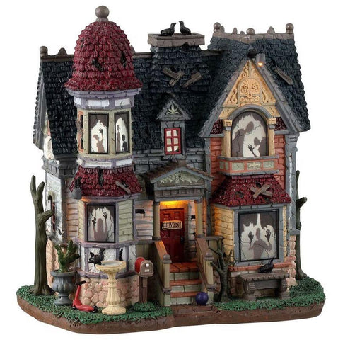 Lemax Spooky Town The House Of Shadows #35004 - A dilapidated house with red and black shingled roofs depicts numerous shadowed ghosts and monsters in the windows.