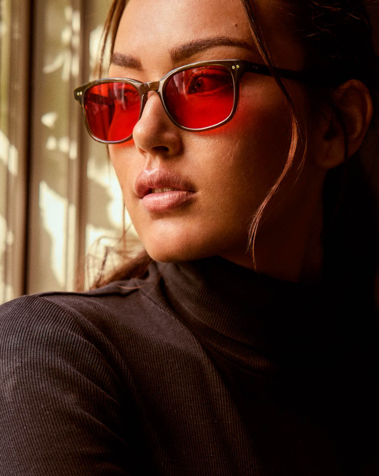 Model is wearing Filter Optix blue blocking glasses with Red lenses