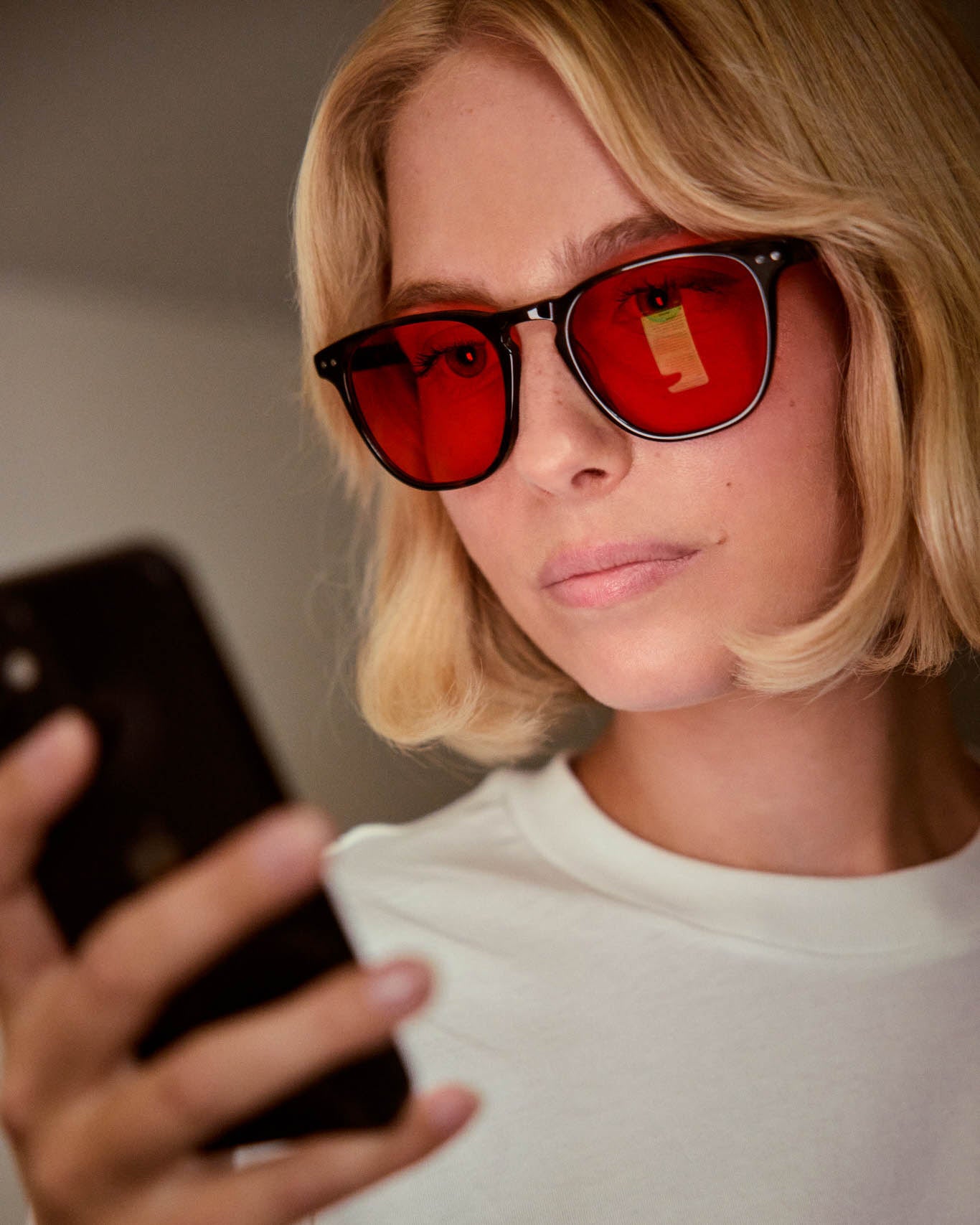 Model is wearing Filter Optix blue blocking glasses with Red lenses