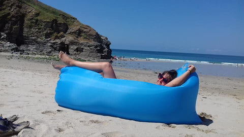 artist Siobhan Purdy in a blue inflatable on a Cornish beach 