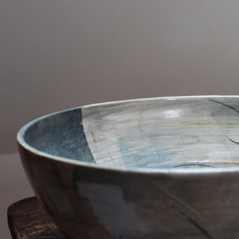 part of a large blue ceramic bowl on a wooden table