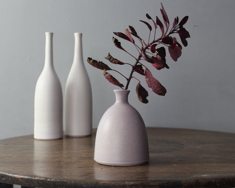 Ceramic bottles by Lucy Burley on a wooden table 