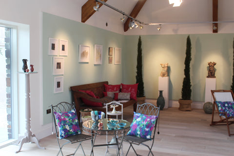 Gallery interior - art and sculpture in a room with pale green walls