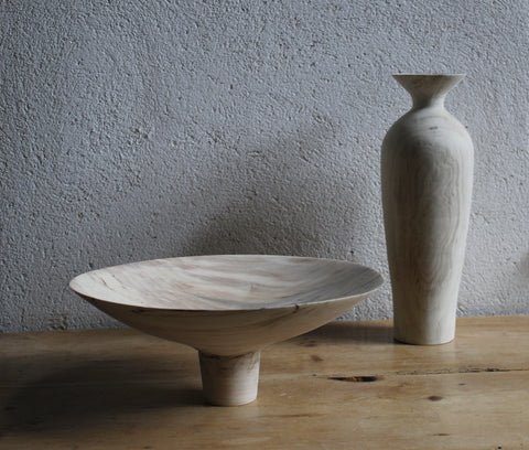 wooden bowl and tall vase on a wooden table they've been made by Jayne Armstrong 