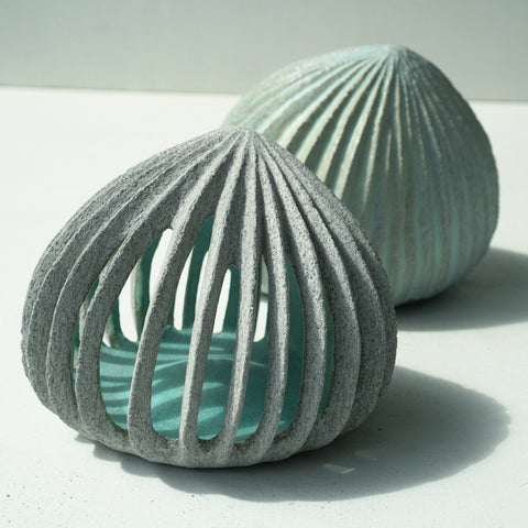 Hand carved ceramic pods with pale blue insides by ceramic artist Michele Bianco 