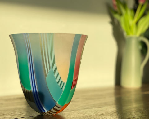 Ruth Shelley multicoloured glass vessel on a wooden table 