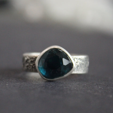 silver ring with a teal blue stone 