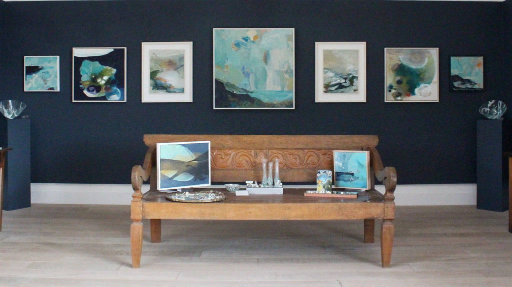 exhibition of paintings on a dark blue wall at the Byre Gallery in Cornwall summer 2022