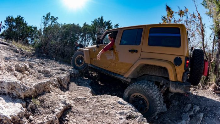 gold jeep climbing rocky trail