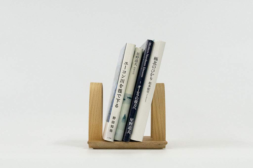 A solid wood book stand that can hold 3 to 4 books.