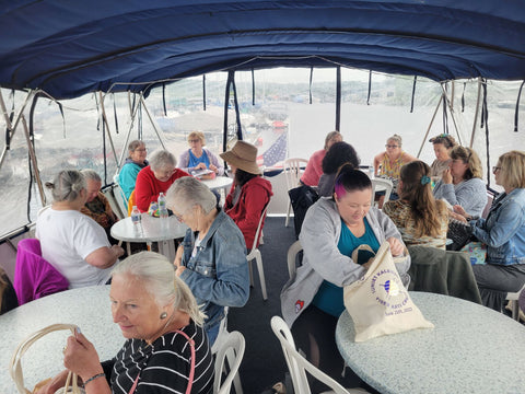 Upper deck of the boat with people looking through their swag bags