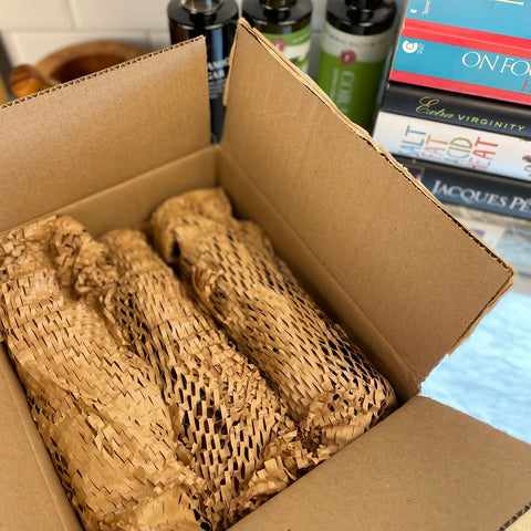 Standard shipping carton for three bottles of oil or vinegar shown wrapped in eco-friendly "geami" honeycomb style packaging.