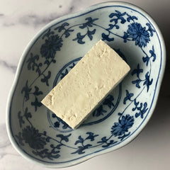 Firm tofu, directly from the package, shown in a decorative Chinese porcelain bowl