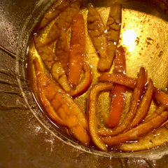 Tangerine peels simmering in sugar syrup in a stainless steel Windsor pan
