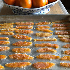 Cooked in sugar syrup and dredged in granulated sugar, orange peels dry and harden on a sheet pan.