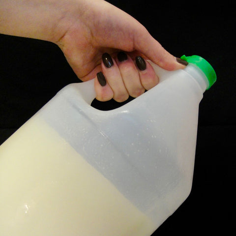 Opaque gallon jug about half full of refined olive oil. Held at an angle it is clear that it is completely solidified.