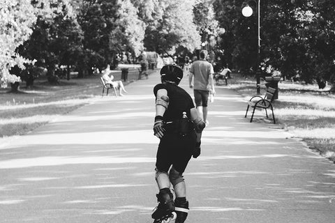 Pawel inline skating with protective equipment in park - OmniRoller