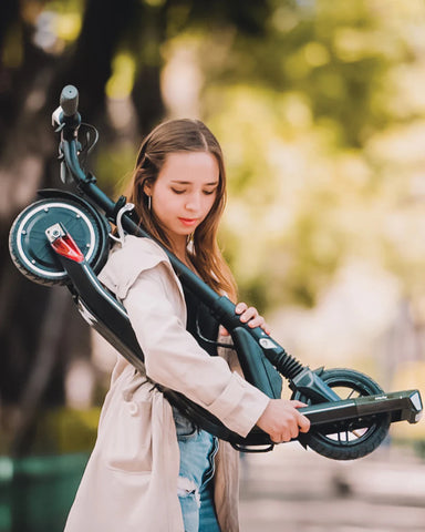 Mujer cargando scooter eléctrico plegado sobre su hombro OmniRoller