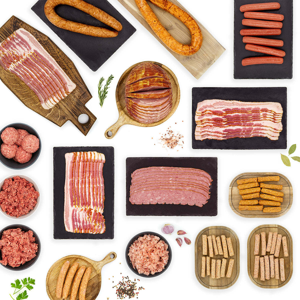 Image of various pork products on a variety of cutting boards and in bowls featuring the all natural pork products in the Ultimate No Sugar Meal Prep Bundle.