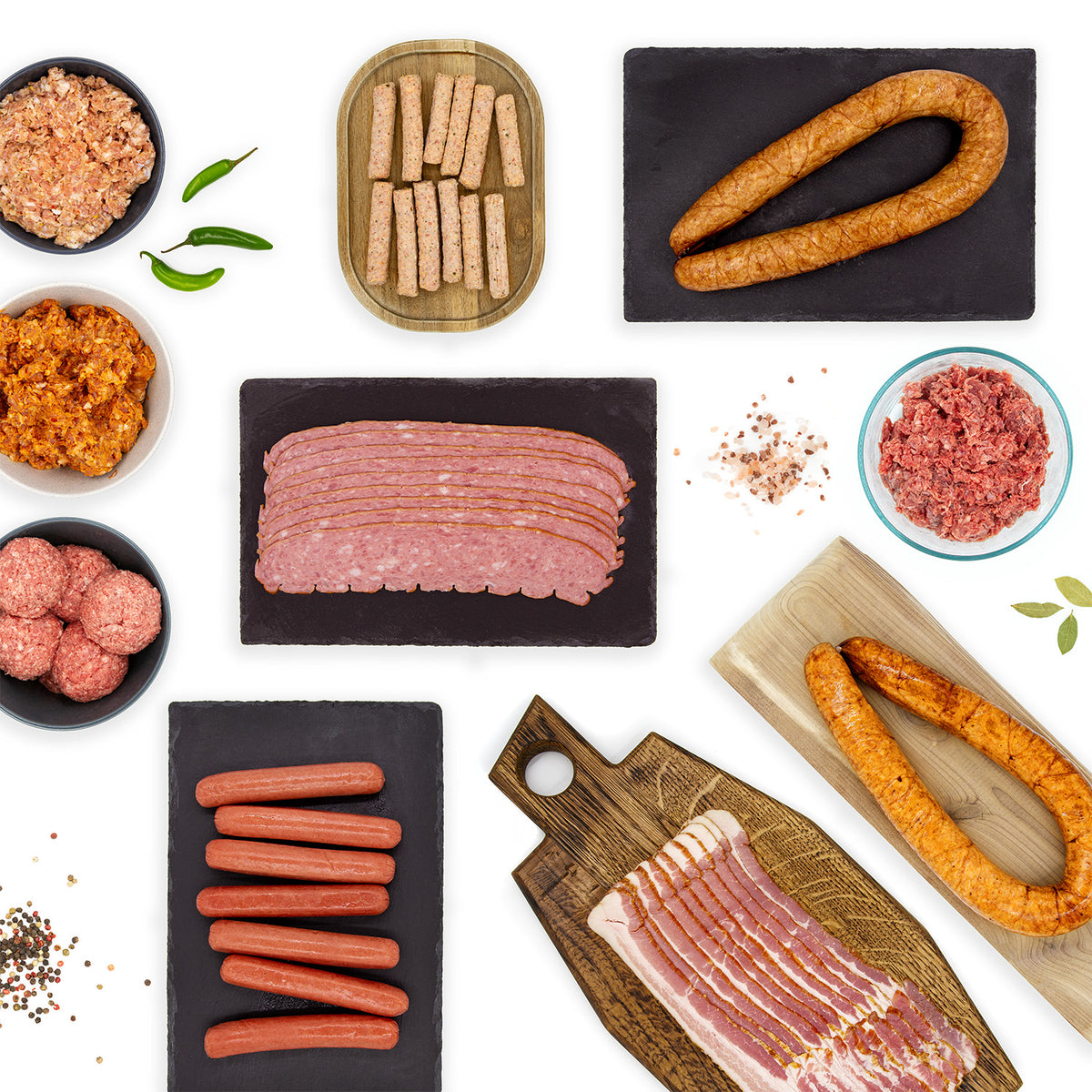 An image featuring all of the pork products included in the Whole30 Variety Pack. This includes various types of bacon, fully cooked sausages, and ground sausages. 