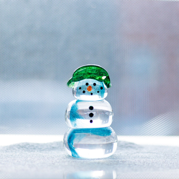 Same layout as the previous snowman, but with a swirl of blue inside, bundled up in a red scarf and green bomber cap.