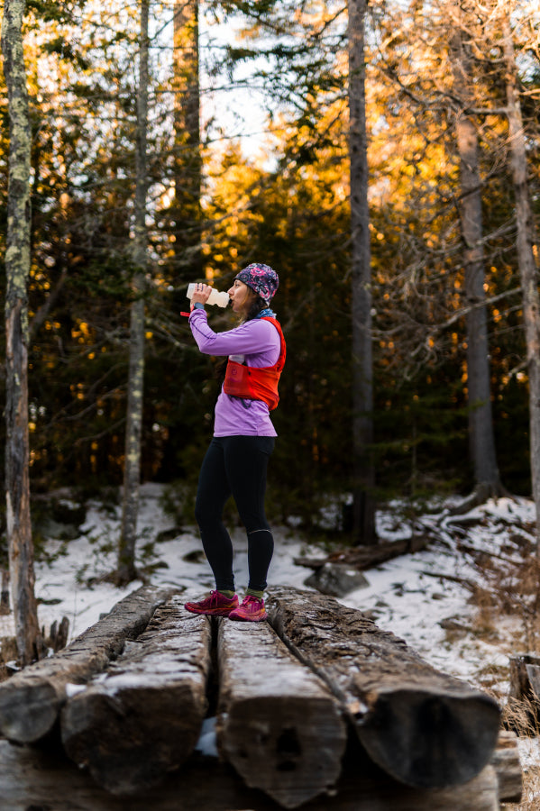 female drinking gnarly hydrate while trail running photo scott martin images