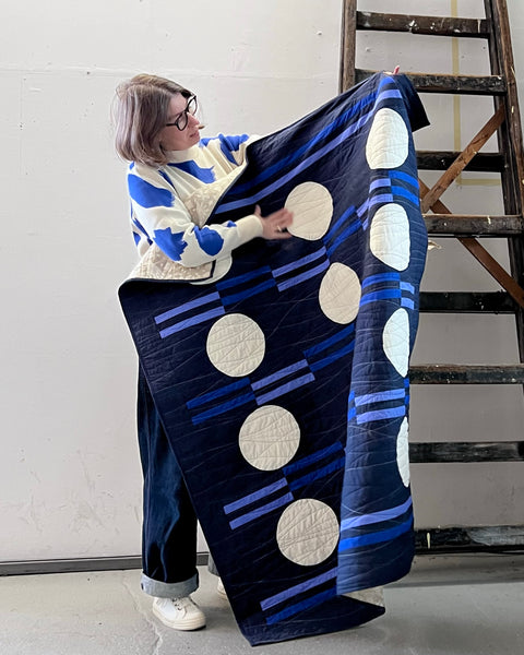 The-hackney-quilter-holding-a-blue-new-moon-throw-size-quilt