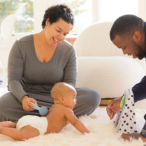 Baby being massaged on floor with floor mirror