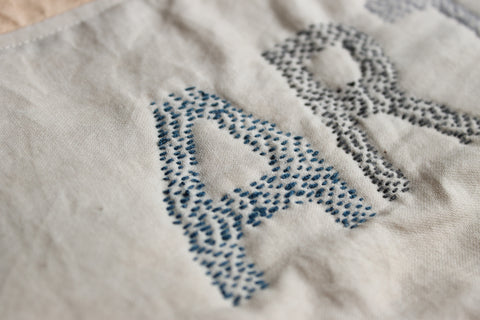 detail of the letter A embroidered with a running stitch