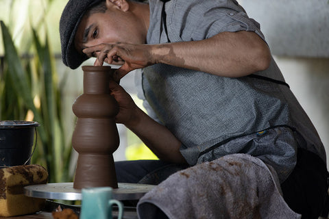 A man doing pottery with his Splash Fabric apron