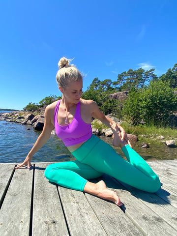 Anette Tallberg doing yoga and wearing Moonah Wear pink yoga top and high waist turquoise yoga leggings