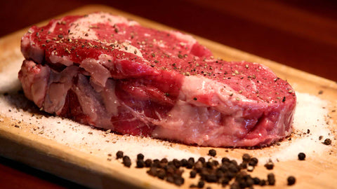 Ribeye Steak being seasoned