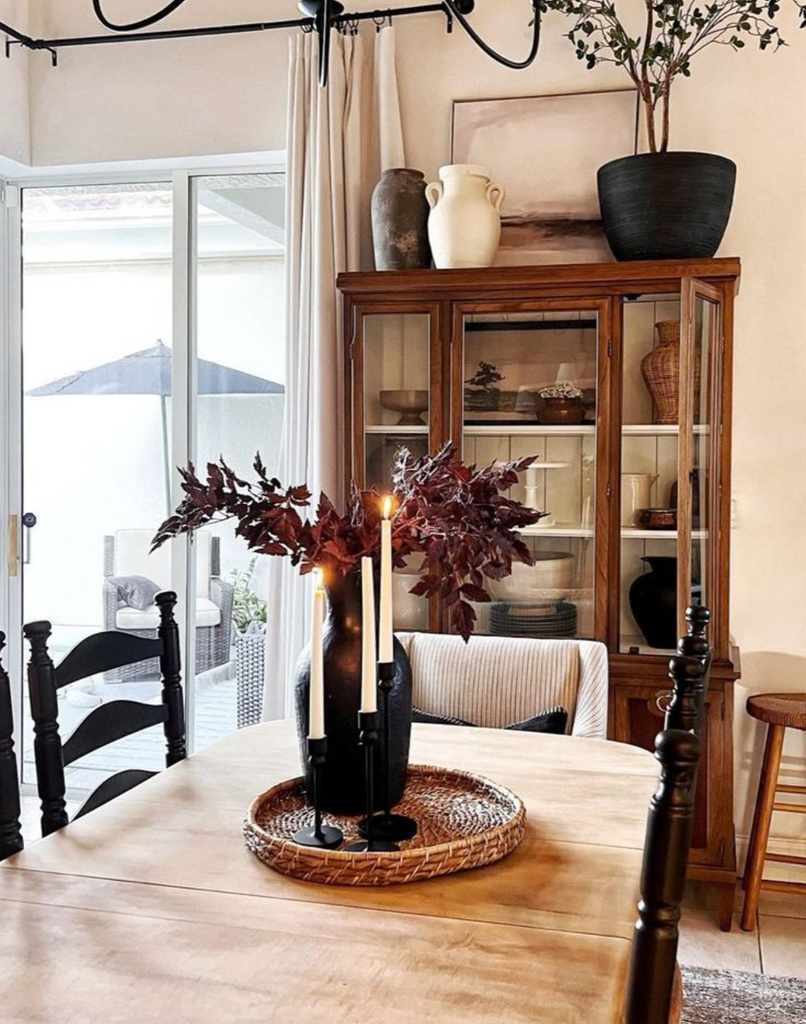 Combine old and new decor to create a collected home style. Dining room scene with vintage table and chairs mixed with modern touches of art, pottery and accessories.