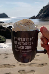 A hand holding a mug of hot chocolate at readymoney cove fowey