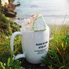 A mug of hot chocolate with a christmas tree shaped marshmallow at Readymoney Cove Fowey