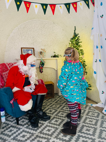 Two girls meet Father Christmas at the Readymoney Cove Grotto in Fowey