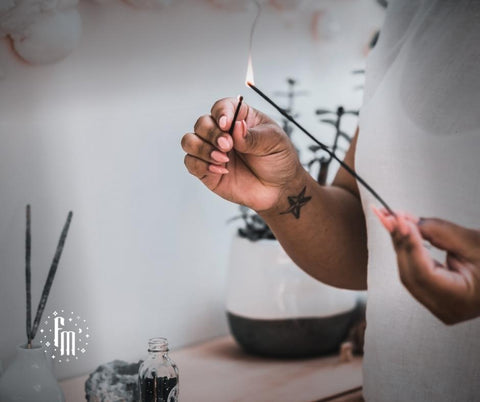 woman lighting an incense stick