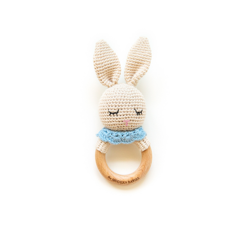 Crochet bunny with blue bib. Light tan color crochet bunny with sleeping eyes. Bunny rattle with closed eyes on beech wood ring. Handmade baby rattle and toy for newborn and infants. 